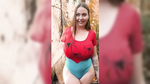 Busty Spider Girl in skimpy red top and blue thong posing in woods