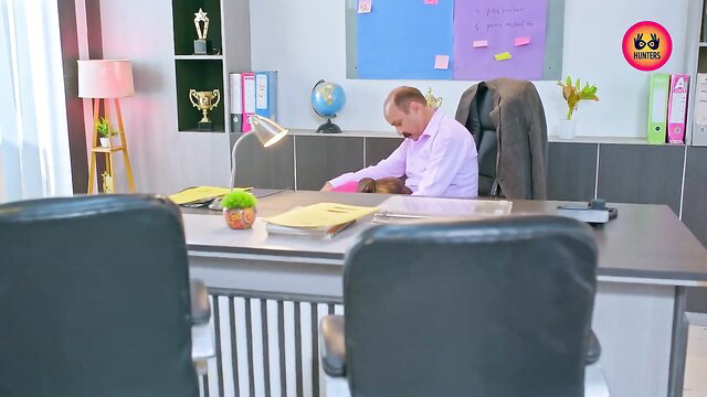 Mature Indian office man in suit at desk, professional headshot
