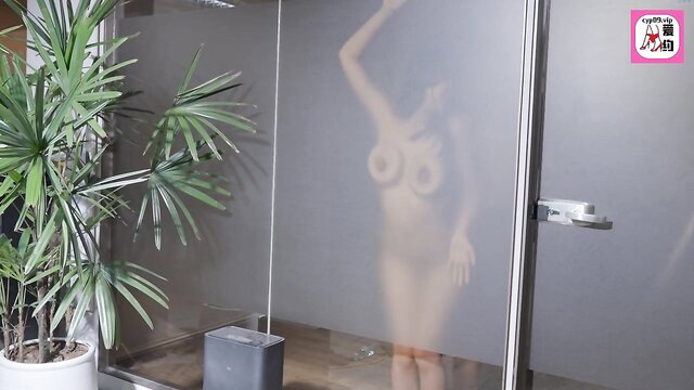 Silhouetted Asian babe nude showering in steamy glass, big tits visible