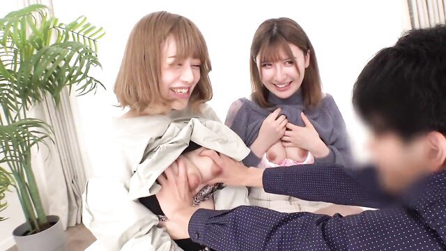 Two smiling Japanese women groping man's crotch in JAV threesome tease
