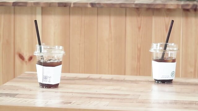 Two iced coffee cups on table in Bosomy Mom Korean hot movie thumbnail