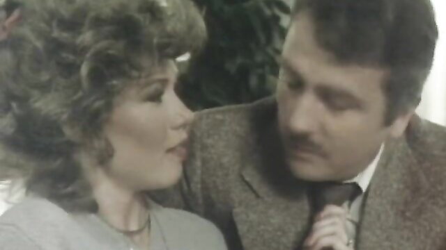 Vintage 1982 Lolita closeup of big-haired brunette gazing at suited man