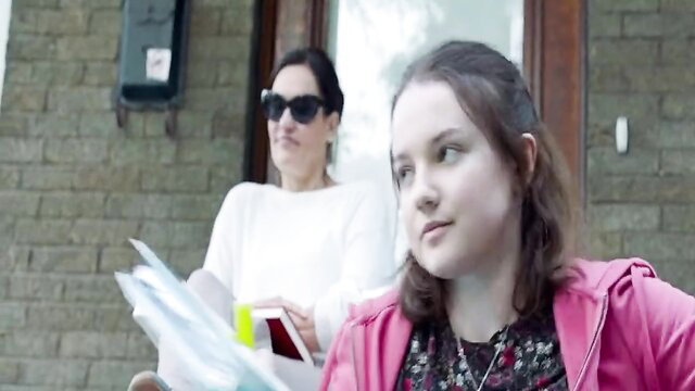 Two women at door, mature brunette in shades and young brunette in pink hoodie