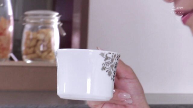 Reiko Kobayakawa holds white mug in JAV NTR kitchen scene