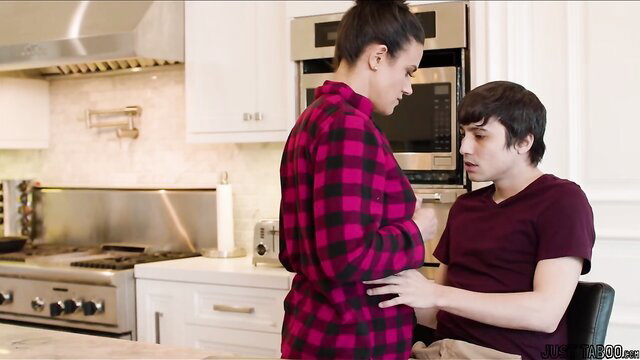 Stepmom in plaid shirt touches stepson intimately in kitchen