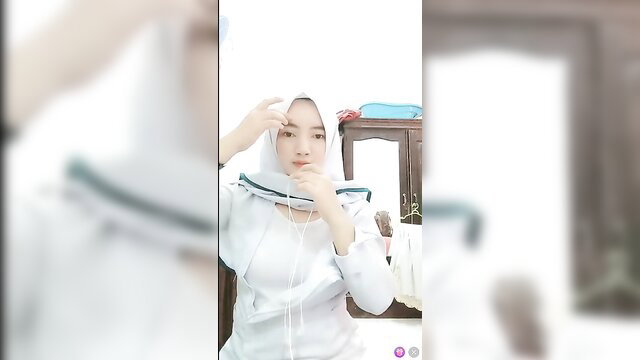 Sexy Asian nurse in white hijab adjusting outfit, teasing closeup