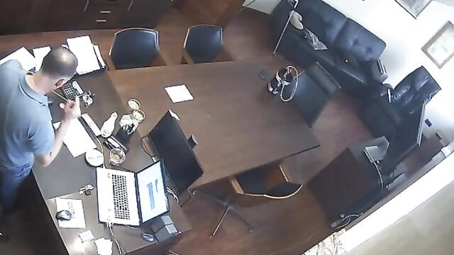 Bald Russian boss on phone at desk in hidden cam office scene