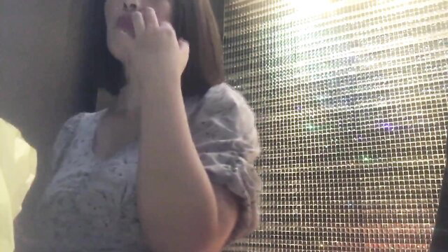 Asian amateur smokes closeup in sheer dress, teasing lips