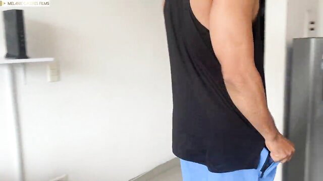 Hot Asian guy in tank top pulling down blue shorts in kitchen tease