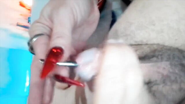 Femme fatale with red nails trimming shemale cock closeup