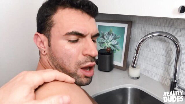 Hot plumber guy getting neck kissed in kitchen sink scene