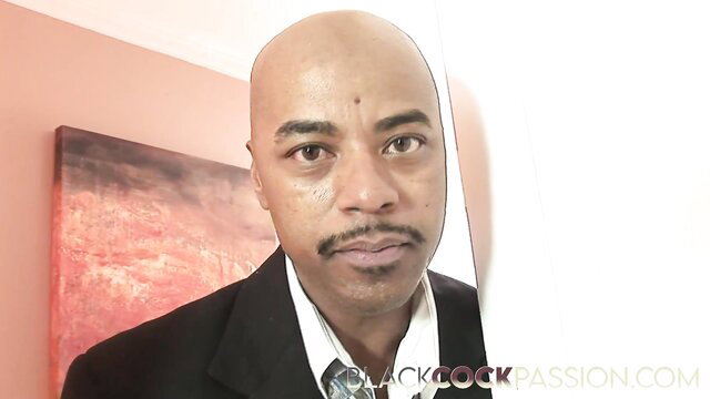 Bald Black Man in Suit Stares Intensely at Camera