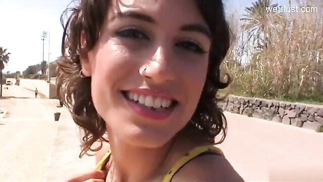 Smiling brunette GF with nose piercing on sunny outdoor path