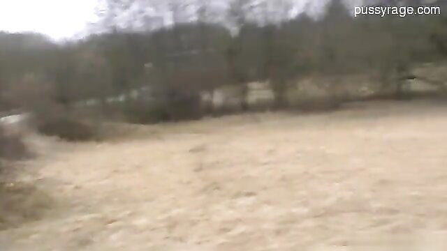 Amateur outdoor scene in woods, bare dirt field and trees