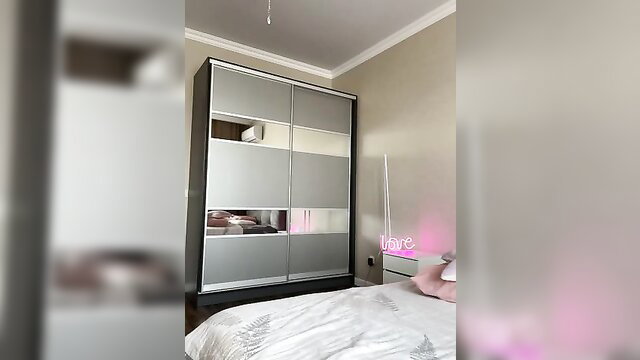 Jessislove in a bedroom with neon sign