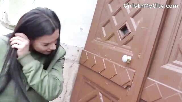 Long-haired Latina adjusting hair at door in green jacket casting pickup