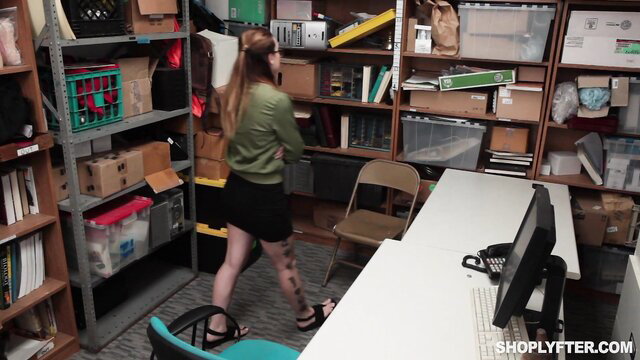 Kat Monroe in short skirt at desk in shoplifter security room