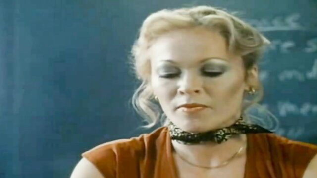Vintage blonde MILF with heavy makeup in low-cut top, closeup portrait