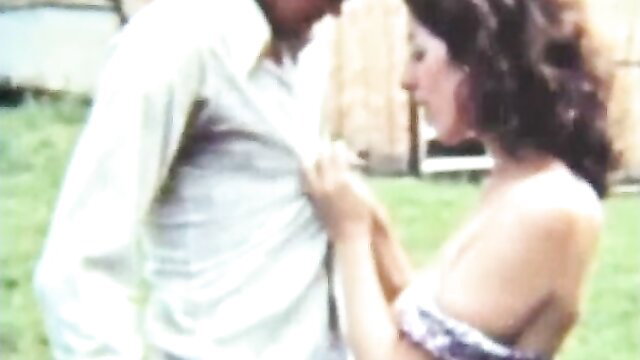 Farmers Daughter vintage XXX: busty brunette in dress gropes man's crotch outdoors