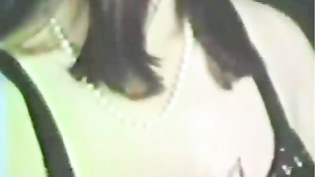 Vintage porn closeup of Asian woman's pearl necklace and black dress