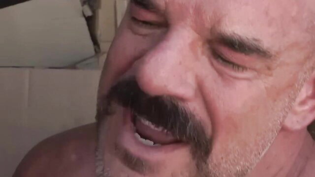Bald Dirty Daddy laughing with mustache in sling sex scene