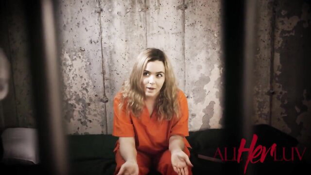 Natasha Nice in orange prison jumpsuit, sexy jail cell pose