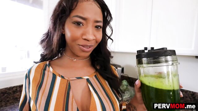 September Reign black MILF holding green smoothie in striped dress