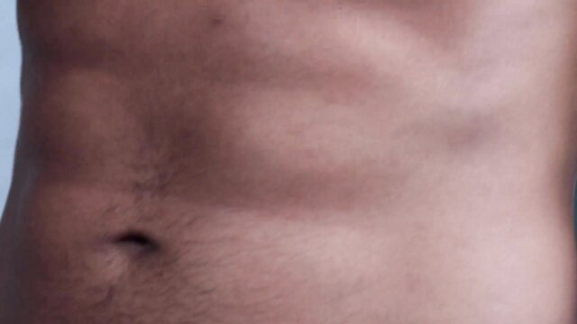 Fit Black man showing ripped abs and happy trail in gay teaser