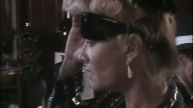 Mature blonde in shades and leather from Oriental Treatment 2 classic porn