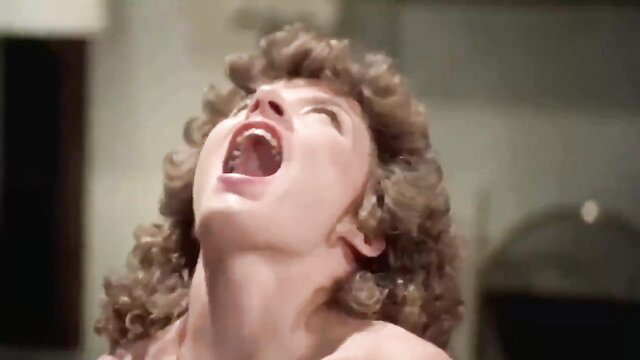 Closeup of curly haired woman in ecstasy, screaming in pleasure