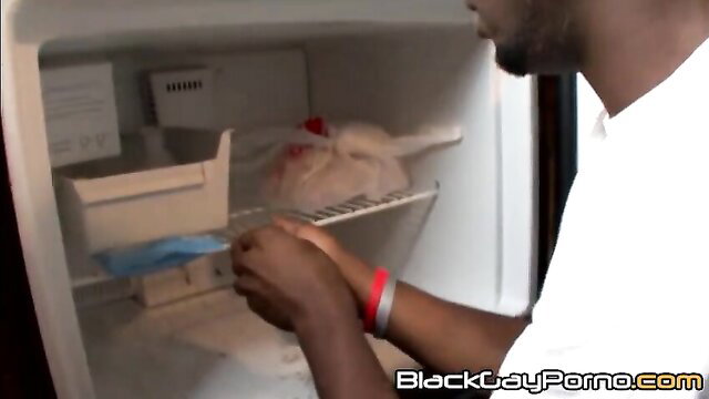 Black thug reaching into fridge with raw chicken, huge black cock bulge