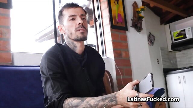 Tattooed Latino man holding phone in kitchen before fucking Hispanic babe