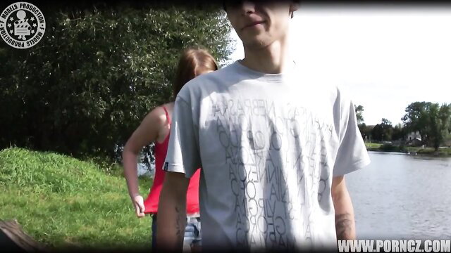 Young couple in tank top and t-shirt outdoors by lake, Public From Bohemia