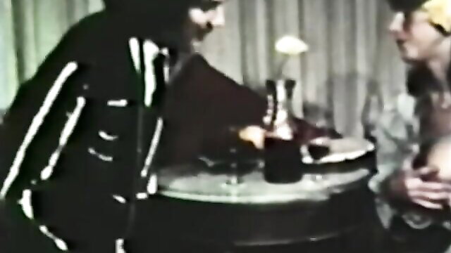 Retro O.Z. Films The Toreador: Shiny latex clad woman gropes man at table