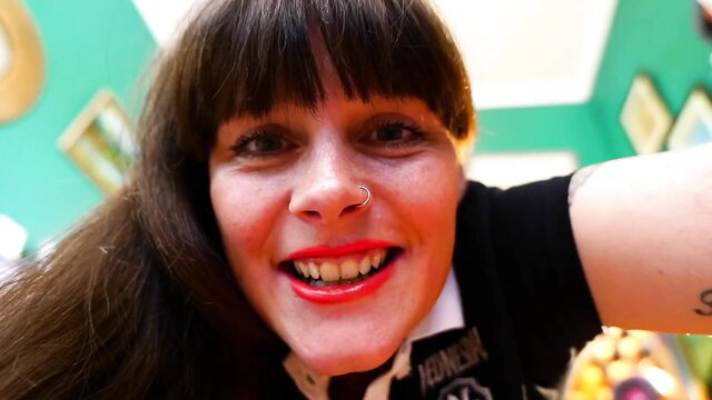 Sydney Harwin smiles seductively in goth vest and collar closeup