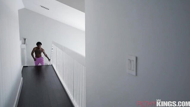 Muscular black man in tight pink briefs on stairs