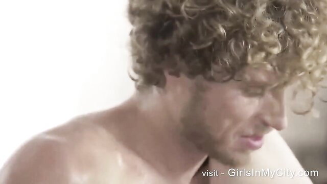 Curly-haired muscular man profile view in intense adult scene