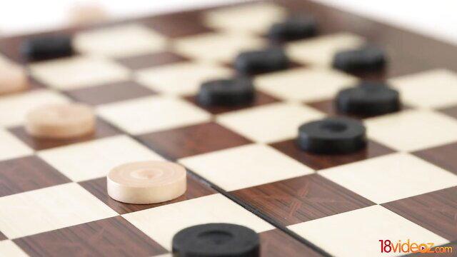 Closeup checkers board with light and dark wooden pieces on wooden table