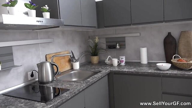 Modern kitchen with gray cabinets, sink, stove and plants