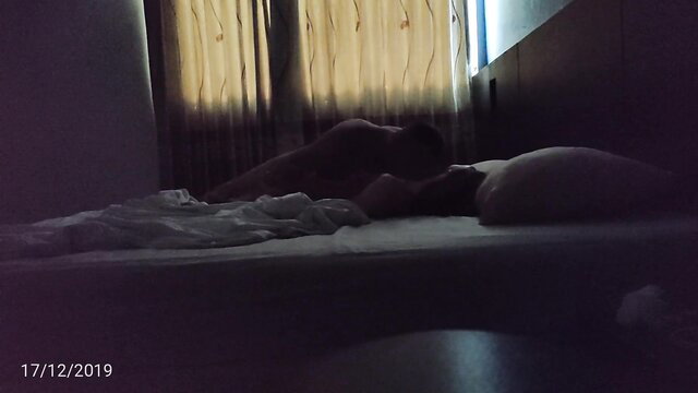 Nude Asian woman lying on bed in dim light, Thailand homemade