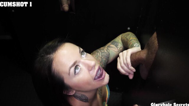 Tattooed brunette gets facial cumshot at gloryhole on big black cock