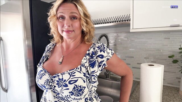 Brianna Beach in floral cleavage dress by kitchen sink