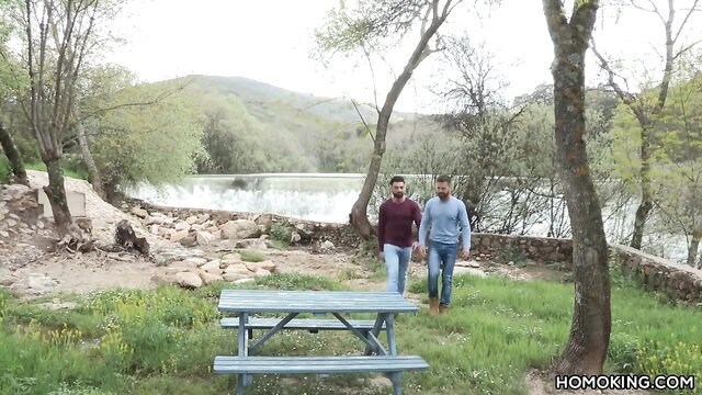 Falcon Studios Latino gay lovers walking hand-in-hand by scenic lake