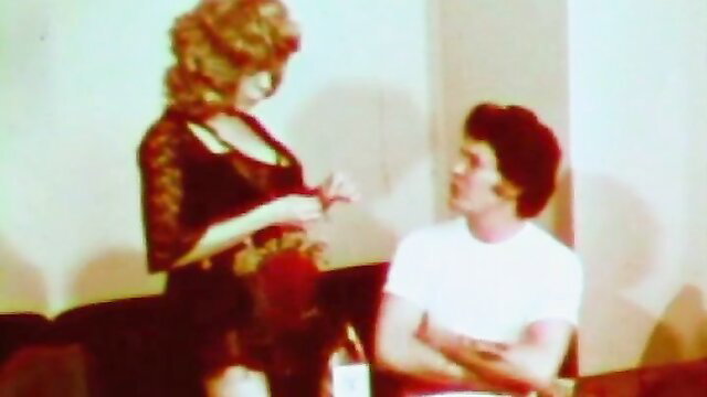 Vintage brunette in sexy black lingerie teases young guy on couch