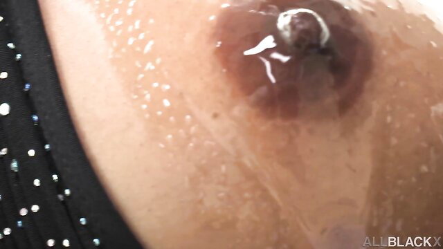 Closeup of shiny black bimbo's wet nipple in shameless adult scene