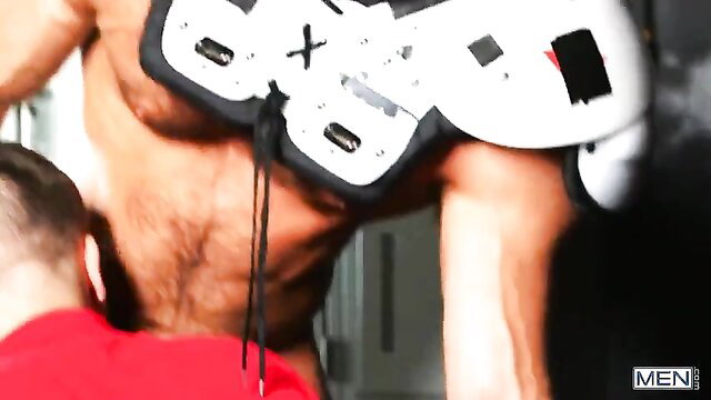 Muscular rugby players in jockstraps grapple intimately, sweaty chests exposed