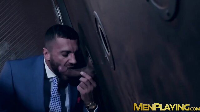 Classy suited hunk sucks gloryhole cock in steamy Men At Play scene