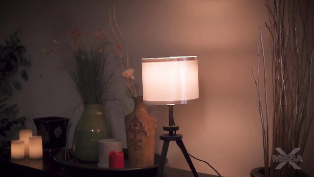 Penny Barber's cozy bedroom table with lamp, candles, vase setup