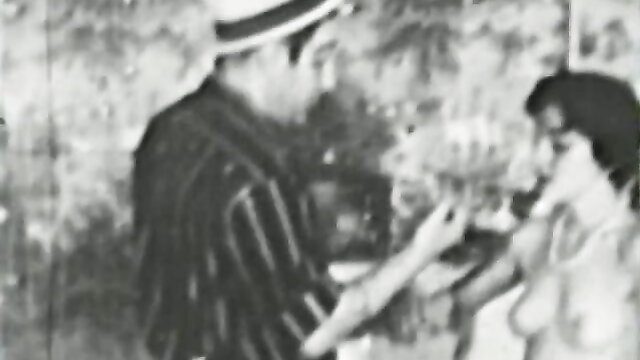 Vintage B&W threesome: suited man gropes topless MILF, lesbian babe watches