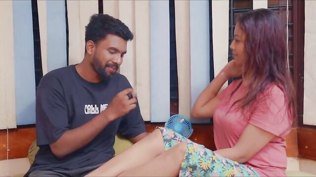 Indian MILF in pink top skirt chats intimately with guy holding fan